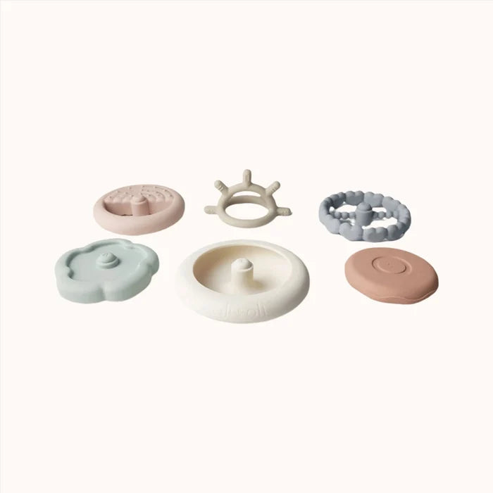 A collection of Ali + Oli Soft Silicone Stacking Rings in various colors displayed on a white background