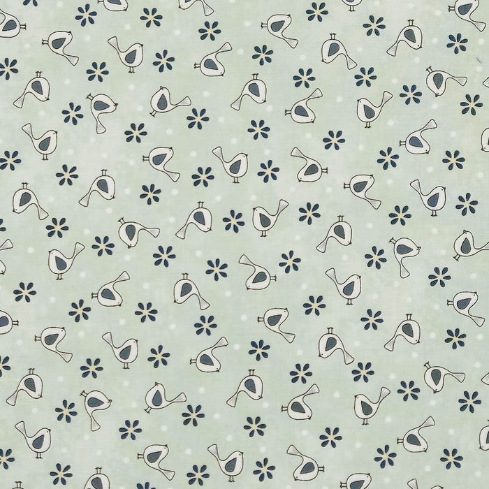 A repeating pattern of small white birds with dark gray bodies and dark blue flowers on a pale mint green cotton fabric with subtle white polka dots.