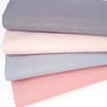 Four cotton fat quarters in blush pink and grey tones, printed with a foil shimmer