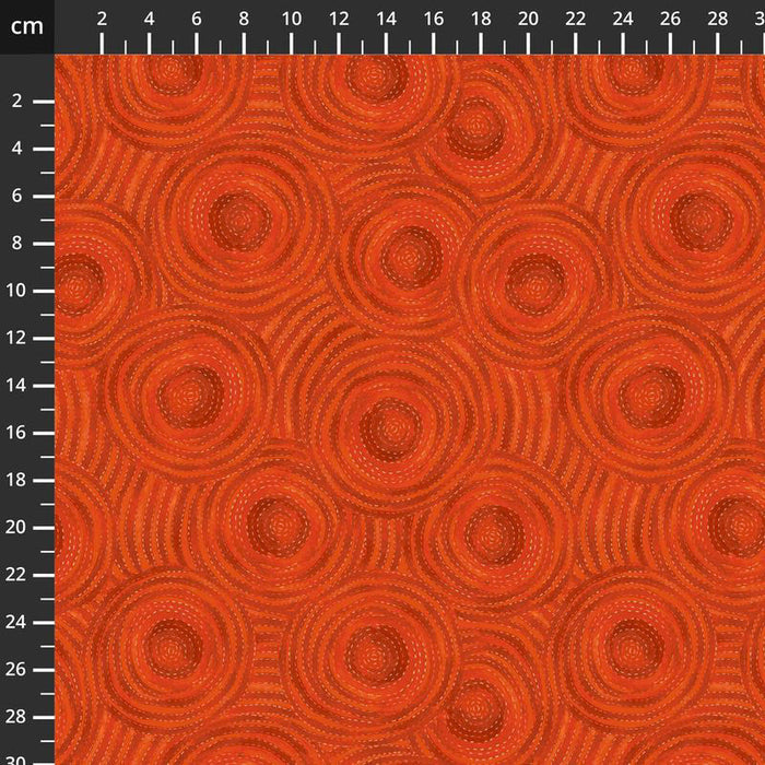 Textured orange quilting fabric with circular patterns on a ruler background