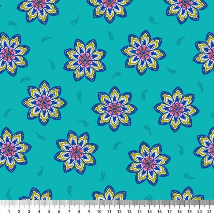 Pattern of colorful flowers on a blue cotton quilting fabric with a ruler at the bottom.