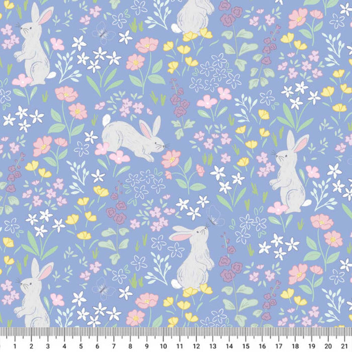 Bunnies printed on a cornflower blue cotton quilting fabric with a cm ruler