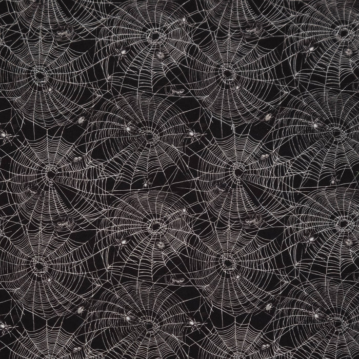 A repeating Halloween-style pattern of white spiderwebs and small spider silhouettes on a black cotton fabric.