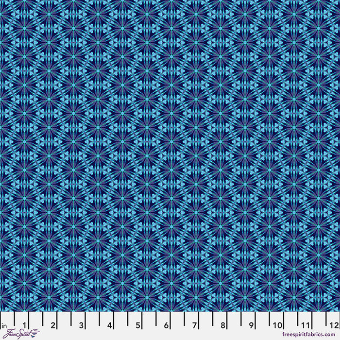 A geometric pattern in bright blues printed on a cotton quilting fabric with a cm ruler