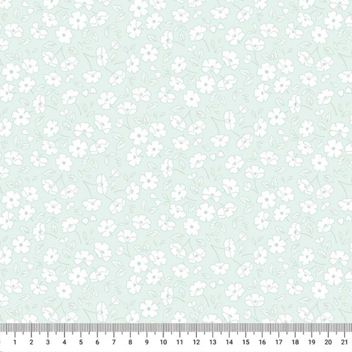 Pattern of small white flowers on a light blue cotton quilting fabric with a ruler at the bottom.