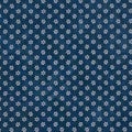 A close-up of a dark blue cotton quilting fabric with a repeating white floral or starburst pattern.