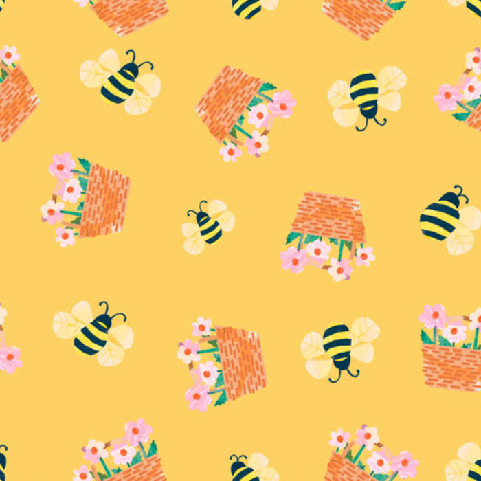 Pattern of bees, beehives, and flowers on a yellow cotton quilting fabric