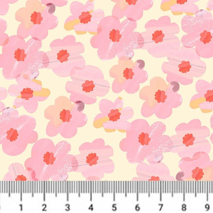 Pattern of pink flowers with red centers on a light yellow cotton quilting fabric, with a ruler at the bottom for scale.