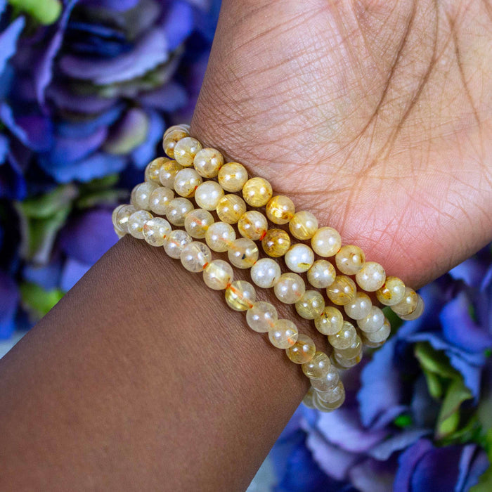 Gold Rutilated Quartz bracelet held against the light