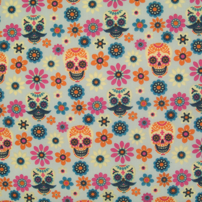 A piece of silver polycotton fabric featuring a pattern with colorful Day of the Dead style skulls and flowers.