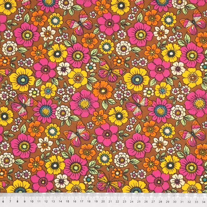 Beautiful butterflies and colourful flowers are printed on a brown polycotton fabric with a cm ruler