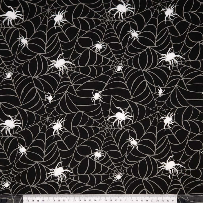 Black fabric with white spider webs and spiders pattern