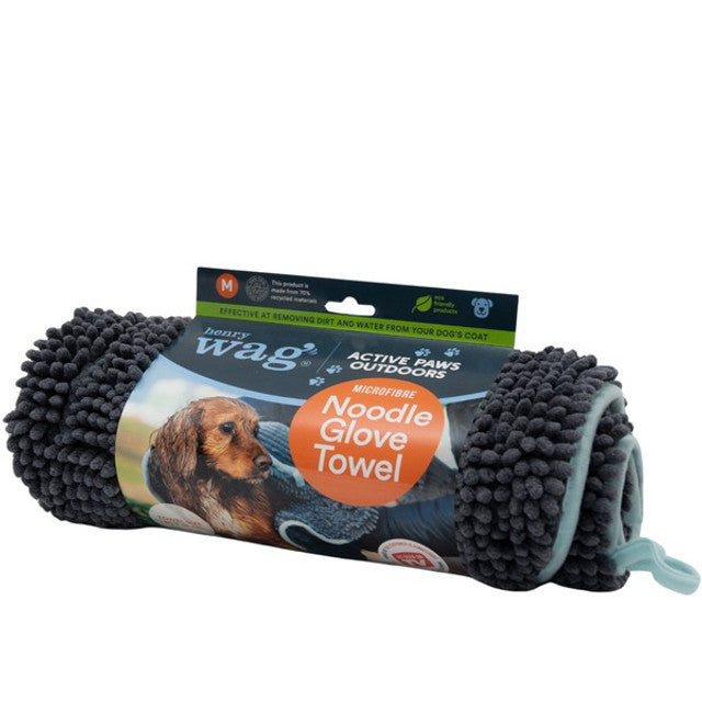 Stock image of the Henry Wag Noodle Glove Towel, on a white background. Towel is grey with noodles, and packaging that shows the towel in use.