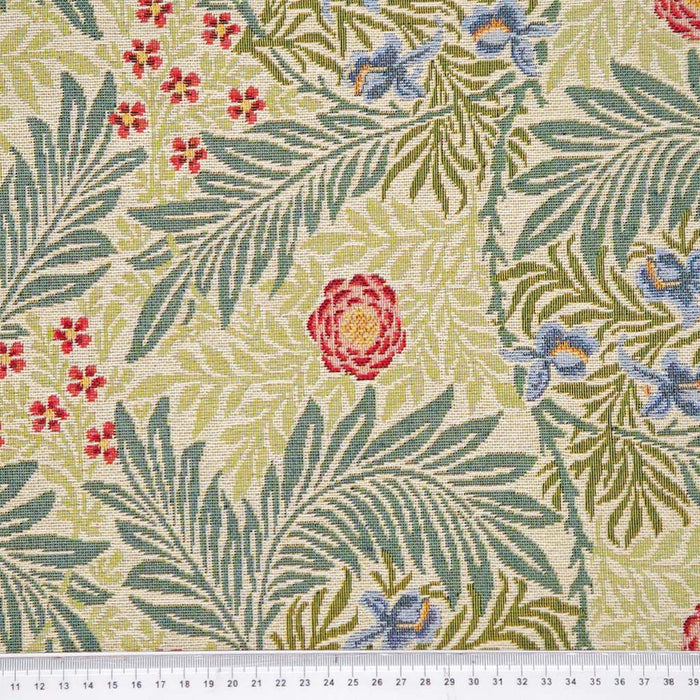 Floral and leaf patterned fabric with red, blue, and green colors on a beige background.