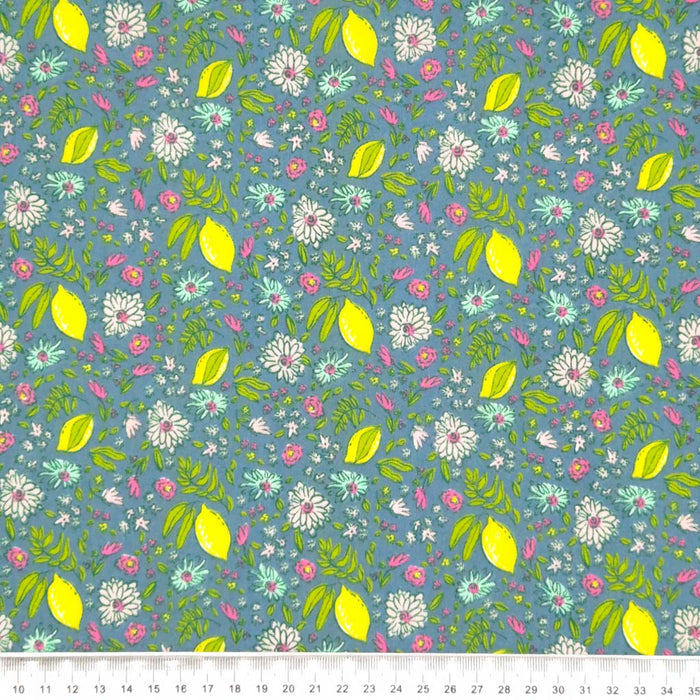 Lemons and ditsy flowers printed on a blue polycotton fabric with a cm ruler