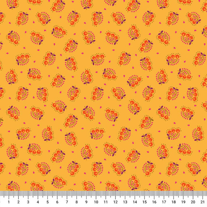 Patterned cotton quilting fabric with orange and purple designs on a yellow background, ruler at the bottom for scale.