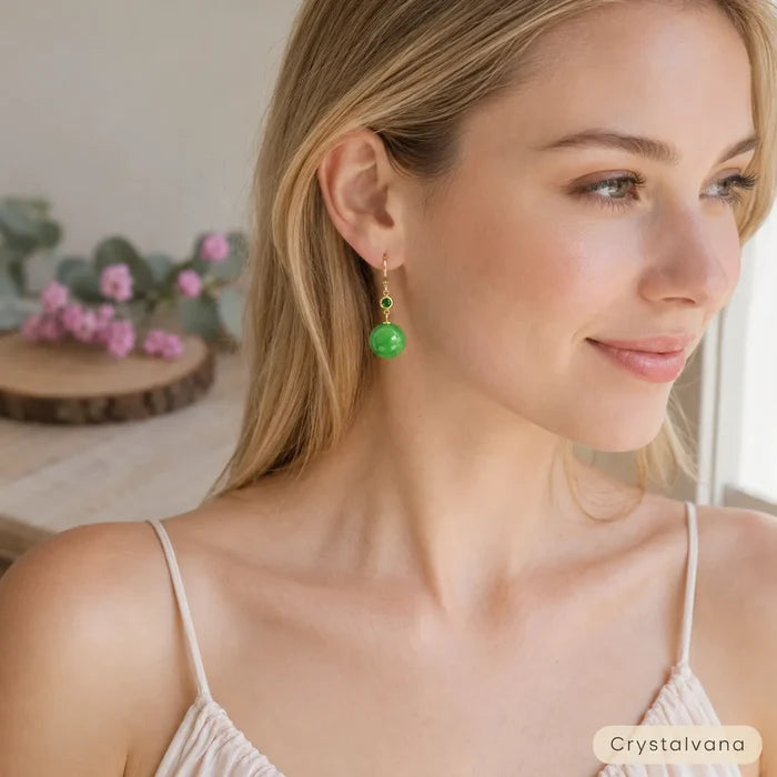 Natural A-grade jadeite yang green round bead earrings flat lay on wood with eucalyptus and pink flowers, Crystalvana