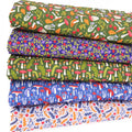 A fat quarter bundle featuring mushrooms and toadstools printed on forest green and blue cotton fabrics