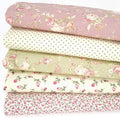Five floral cotton fabrics in a bundle with a rose coloured design on top, a spot, a green rose and two ditsy designs