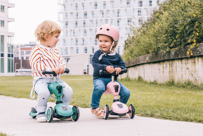 Child enjoying a ride on the rose Scoot & Ride Highwaykick 1 scooter in an outdoor setting