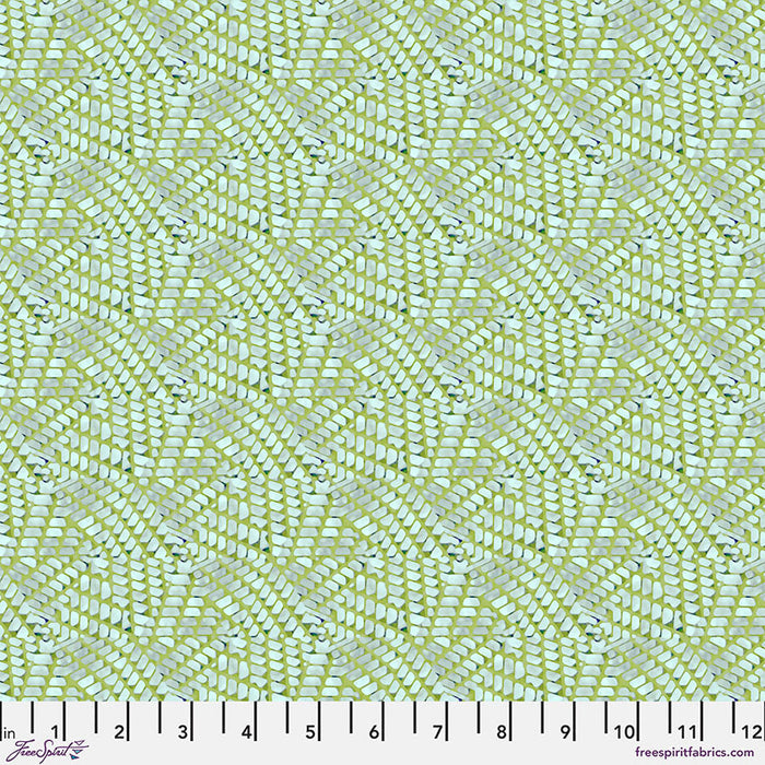 Patterned fabric with a grid-like design on a green cotton quilting fabric, featuring a ruler at the bottom.