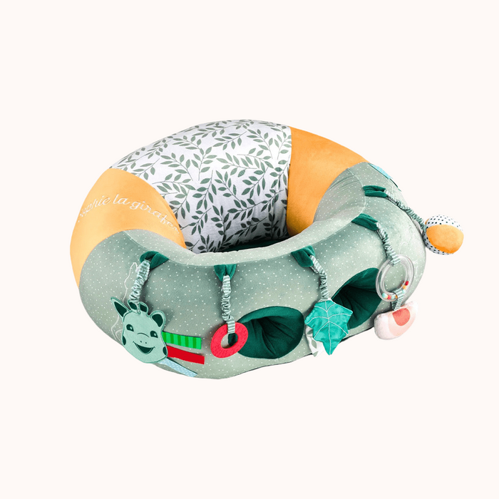 Sophie La Girafe Baby Seat featuring green and yellow patterns and toys to stimulate baby's senses