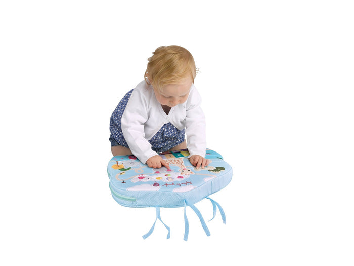 Toddler on the floor playing with Sophie la Girafe Touch & Play Board