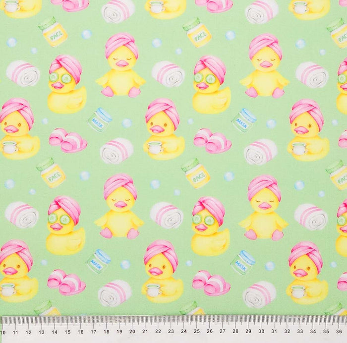 Rubber ducks printed on a mint green polycotton fabric with a cm ruler