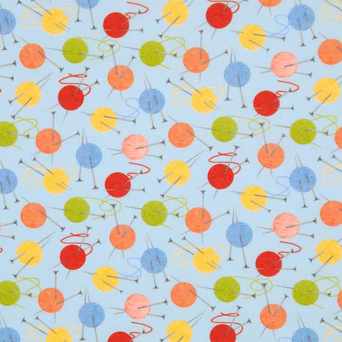 Balls of wool and knitting needles printed on a blue cotton fabric